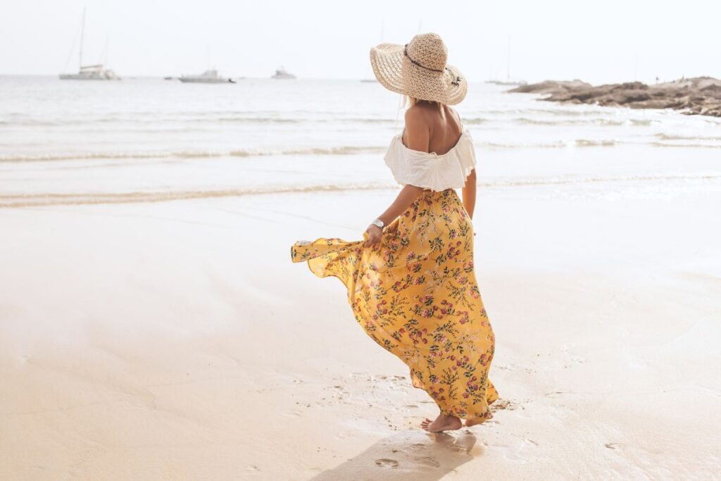 A girl with a hat and  yellow- white cotton clothing which is perfect if you are wondering what to pack for Hawaii