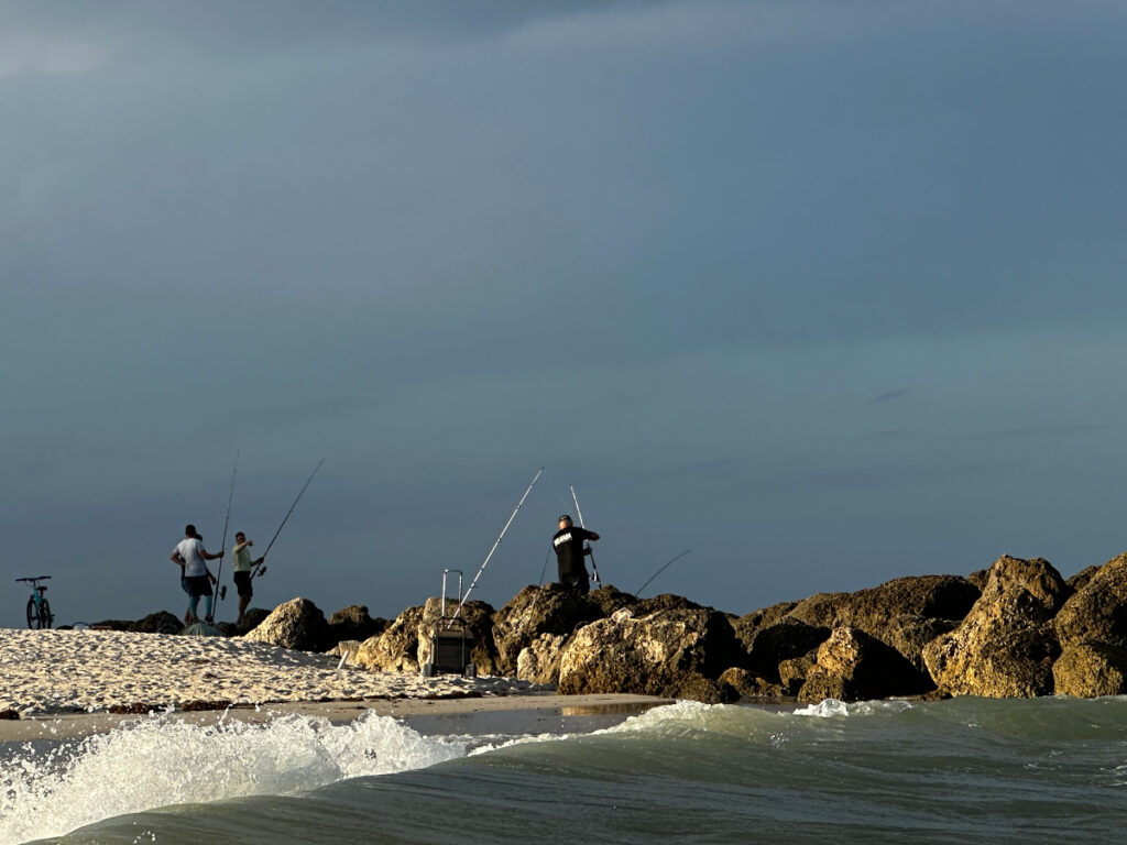 People fishing at the mid beach with the stormy background which is a sight that you will see sometime during your 3 days in Miami.