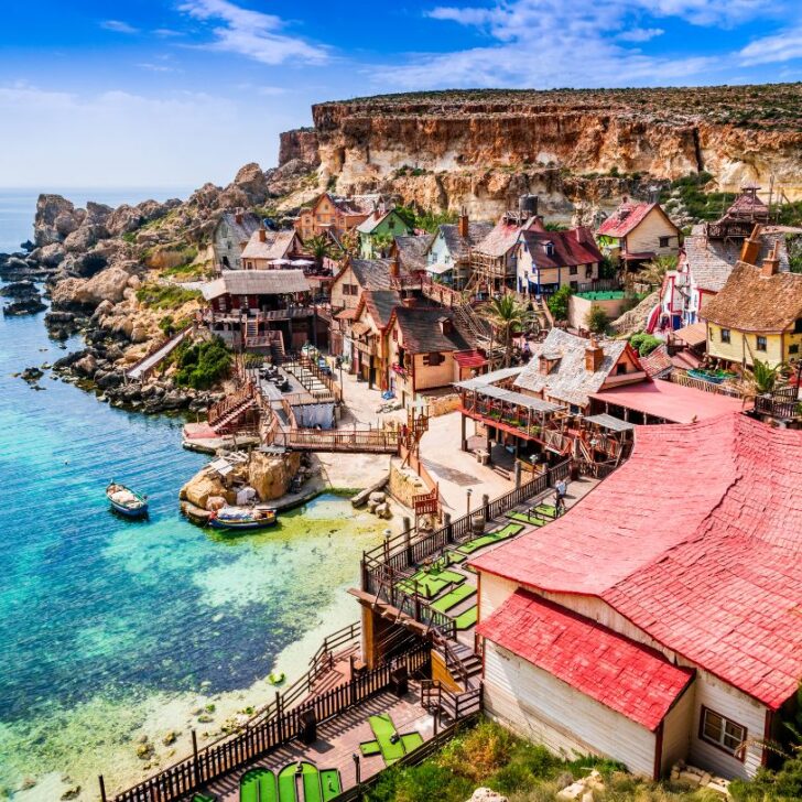A birdseye view of the curious houses in the Popeye village along with the turquois blue sea. One of the places that should be on your 3 days in Malta itinerary.