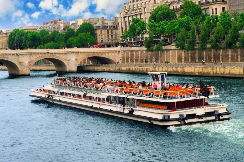 A cruise boat sailing along the river Seine in Paris which is one of the best Paris gift experiences