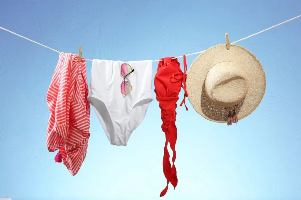 Swimsuits, a sarong, sunglasses and a hat strung on a line are some of the few things that you should pack when you head to Italy in summer