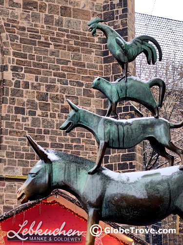A statue of a donkey, dog, cat and rooster on top of each other which is represensitive of the Bremen town musicians.